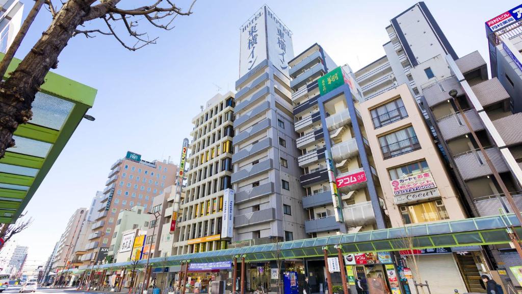 un edificio alto en una calle de la ciudad con edificios en Toyoko Inn Tokyo Kamata Higashi-guchi, en Tokio