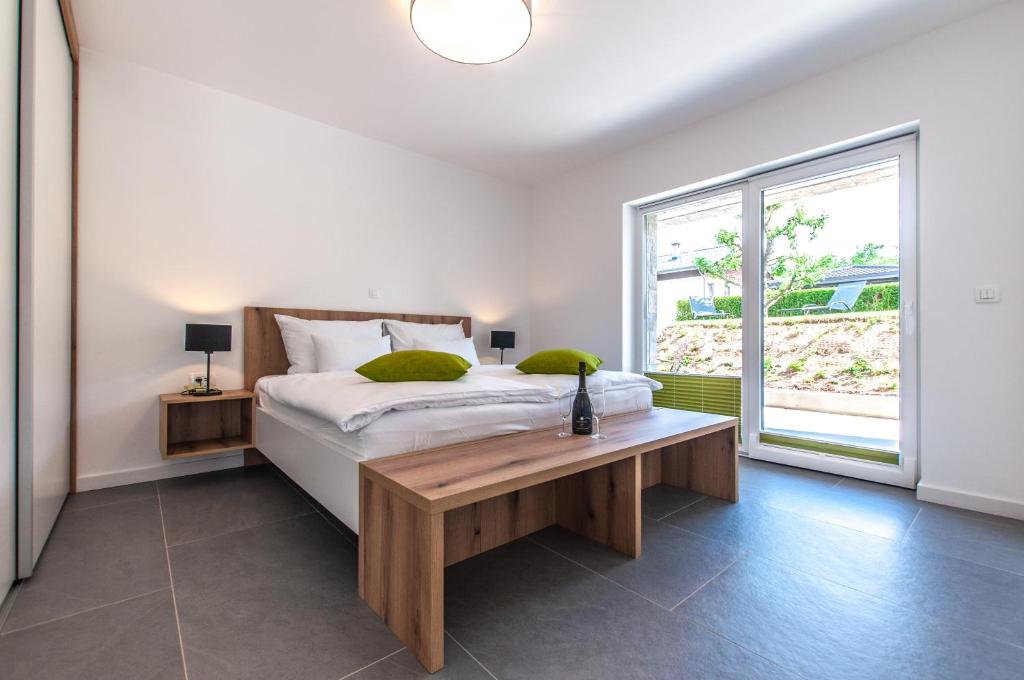 a bedroom with a bed with a table and a window at Apartments Ursus in Bled