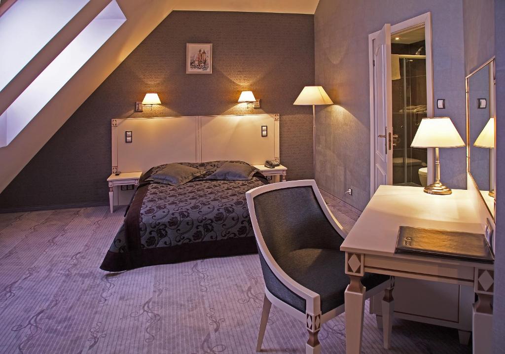 sypialnia z łóżkiem, biurkiem i krzesłem w obiekcie Hotel Wawel w Krakowie