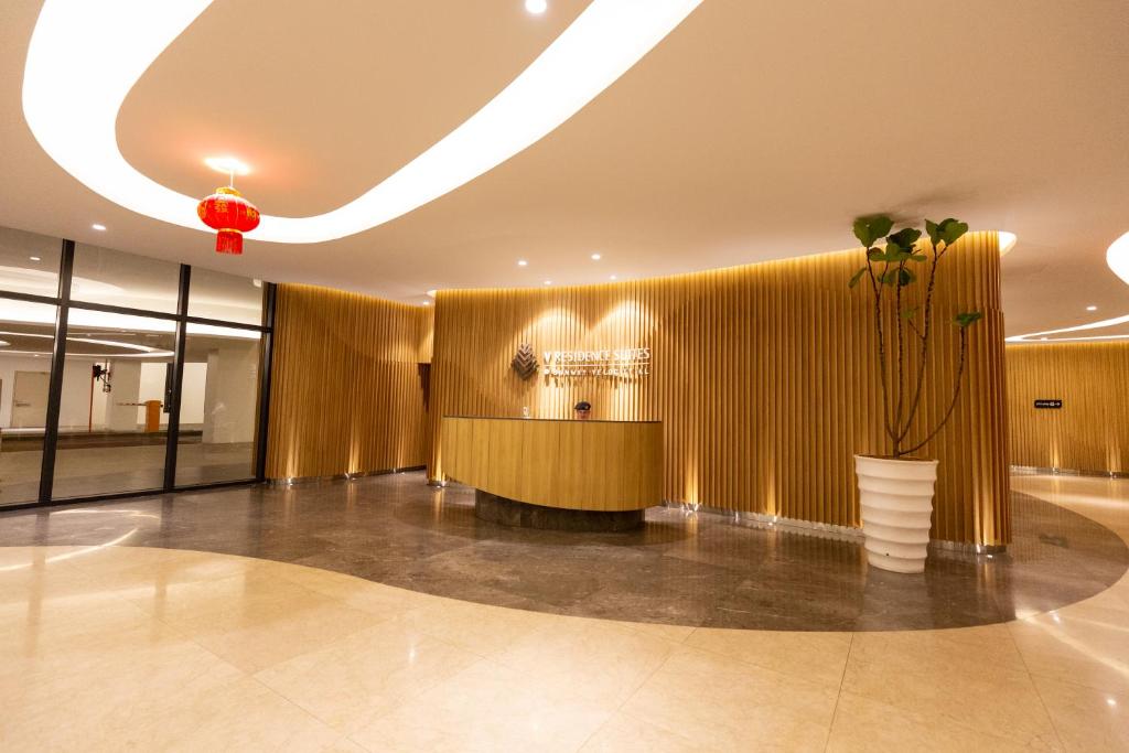a lobby with a gold wall and a vase with a plant at Velocity KL By PSM Luxury Suites in Kuala Lumpur