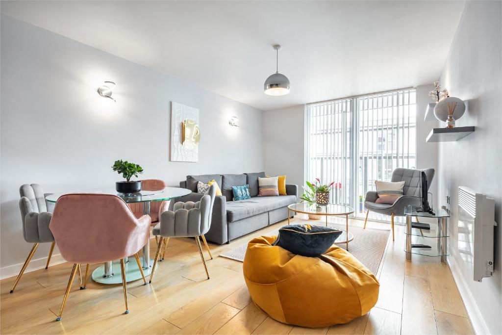 uma sala de estar com um sofá, uma mesa e cadeiras em Stunning Apartment with Underground parking! em Londres