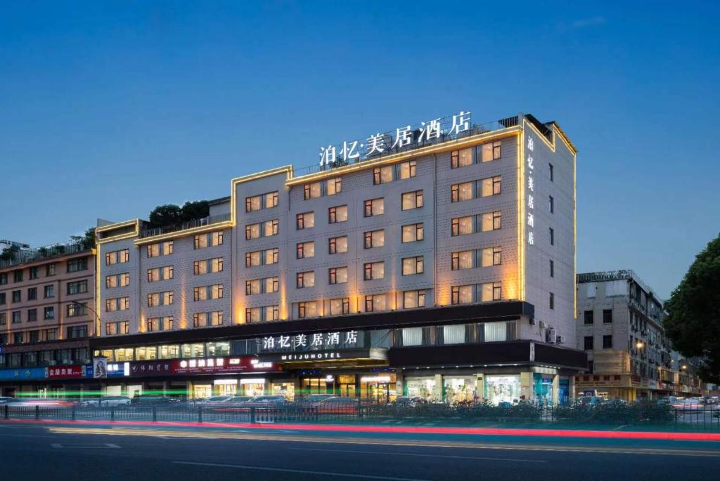 um grande edifício com uma placa em cima em Yiwu Boyi Meiju Hotel义乌市泊忆酒店 em Yiwu