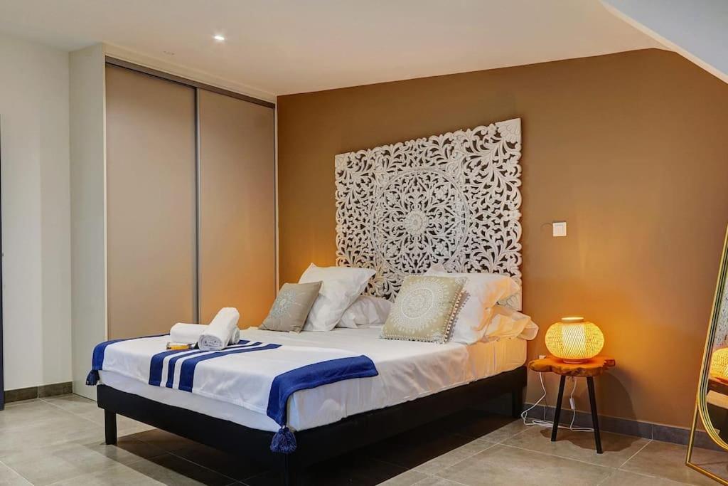 Schlafzimmer mit einem Bett mit einem weißen Kopfteil in der Unterkunft Leu Burgot 2, Appartement 17 in Saint-Leu