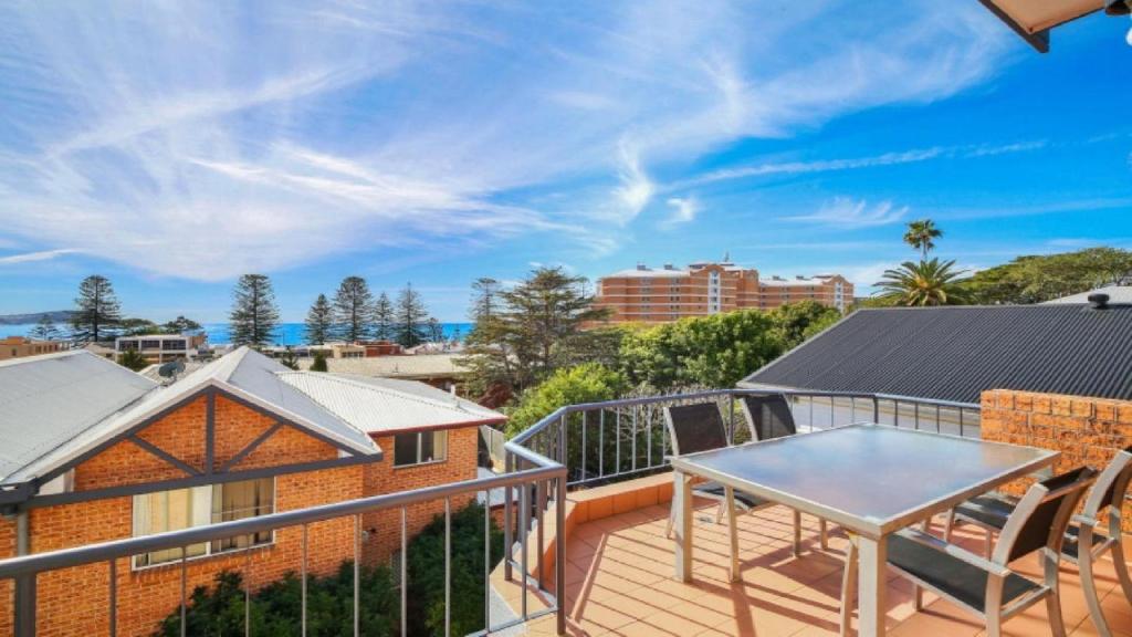 a balcony with a table and a view of the ocean at Sanctuary #12 Accom Holidays in Terrigal