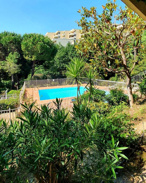 - une piscine dans une cour arborée dans l'établissement Exceptionnel studio Nice proche mer avec piscine, parking et terrasse, à Nice
