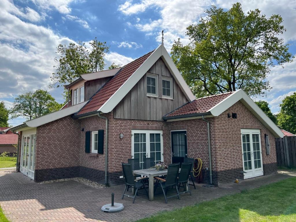 ein kleines Backsteinhaus mit einem Tisch im Hof in der Unterkunft Buitenhuis de Nagtegaal in Hoge-Hexel