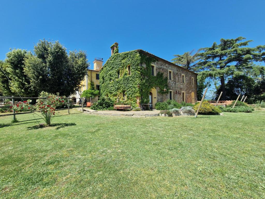 een oud huis is bedekt met klimop in een tuin bij Agriturismo Bio Fattoria di Pietra in Giuncarico