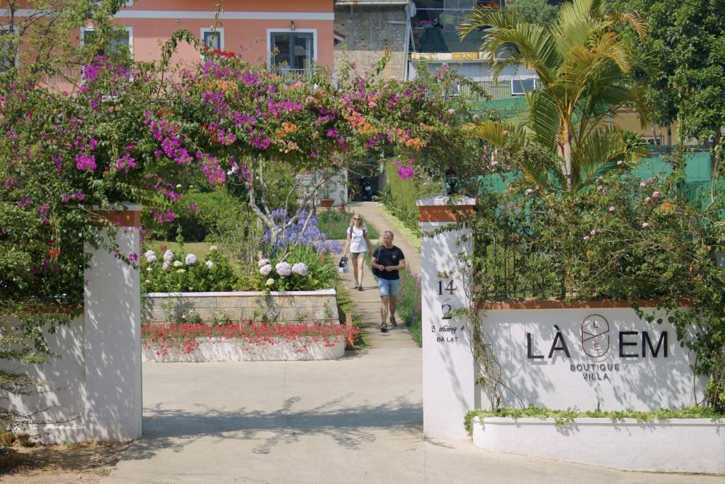 a man walking through a garden with flowers at La Em Boutique Villa in Da Lat