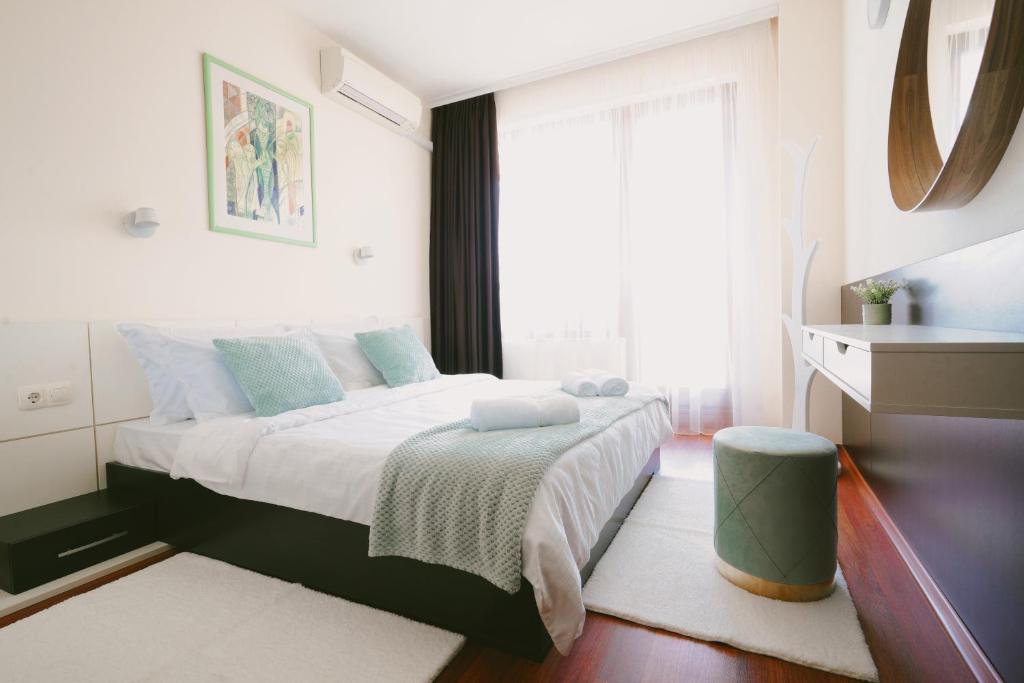 a bedroom with a bed with white sheets and blue pillows at Golden Sands - Two Bedroom apartment on the beach in Golden Sands