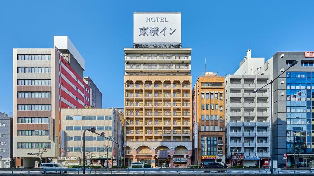 a tall building with a sign on top of it at Toyoko Inn Osaka Namba Nishi in Osaka