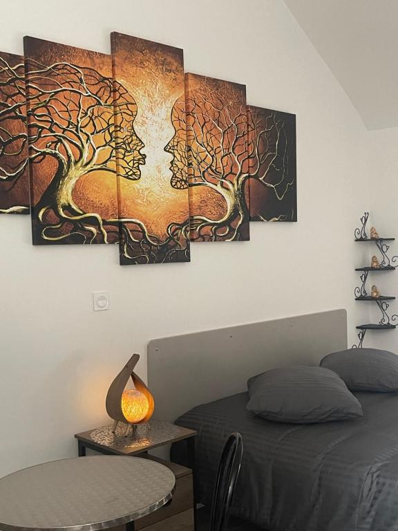 1 dormitorio con 3 pinturas de árboles en la pared en nuitzen, en Boyer