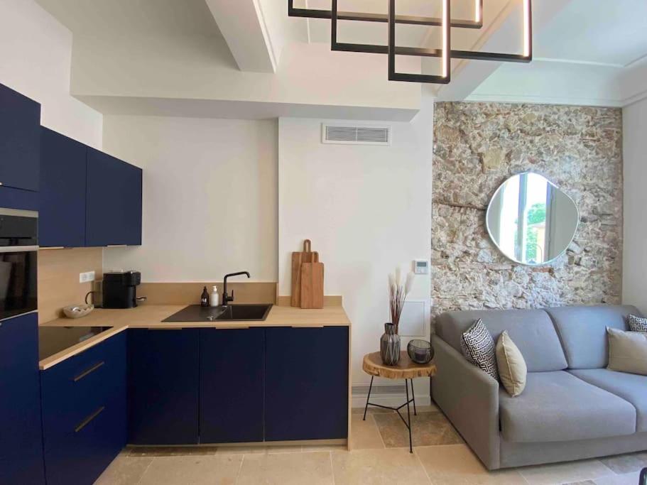 a kitchen and a living room with a blue couch at Au cœur du viel Antibes - Cosy appartement in Antibes