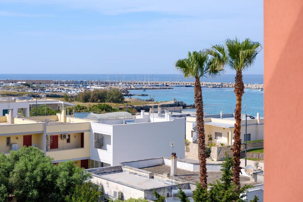 a view of the ocean from a building with palm trees at Casa tra cielo e mare in Salento in San Foca