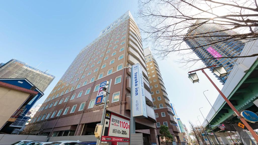 a tall building with a sign on the side of it at Toyoko Inn Nagoya Meieki Minami in Nagoya