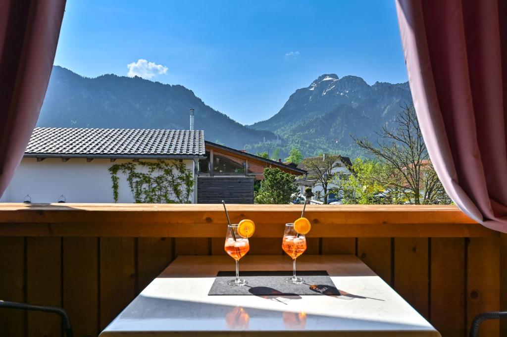 - une table avec deux verres de vin sur le balcon dans l'établissement Ferienwohnung Griabig, à Schwangau