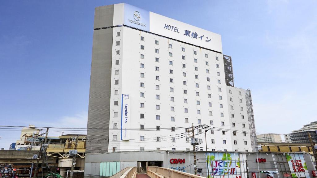 東京的住宿－Toyoko Inn Tokyo Shinagawa Aomono-yokocho-eki，白色的建筑,上面有标志
