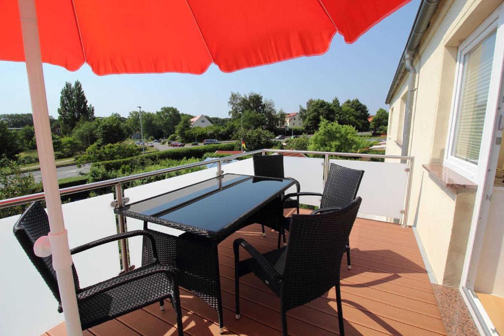 d'une table et de chaises sur un balcon avec un parasol dans l'établissement Ferienwohnung Emely, à Sassnitz
