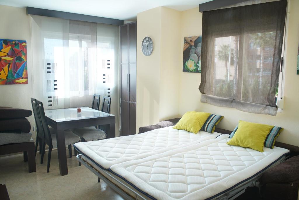 a bed in a room with a table and a window at 1ra Linea Playa Magic World Luxury Apartament PP3 Pet in Oropesa del Mar