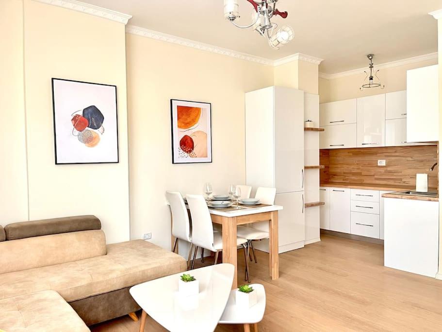 a kitchen and a living room with a table and a couch at Peaceful Condo in City Center in Durrës