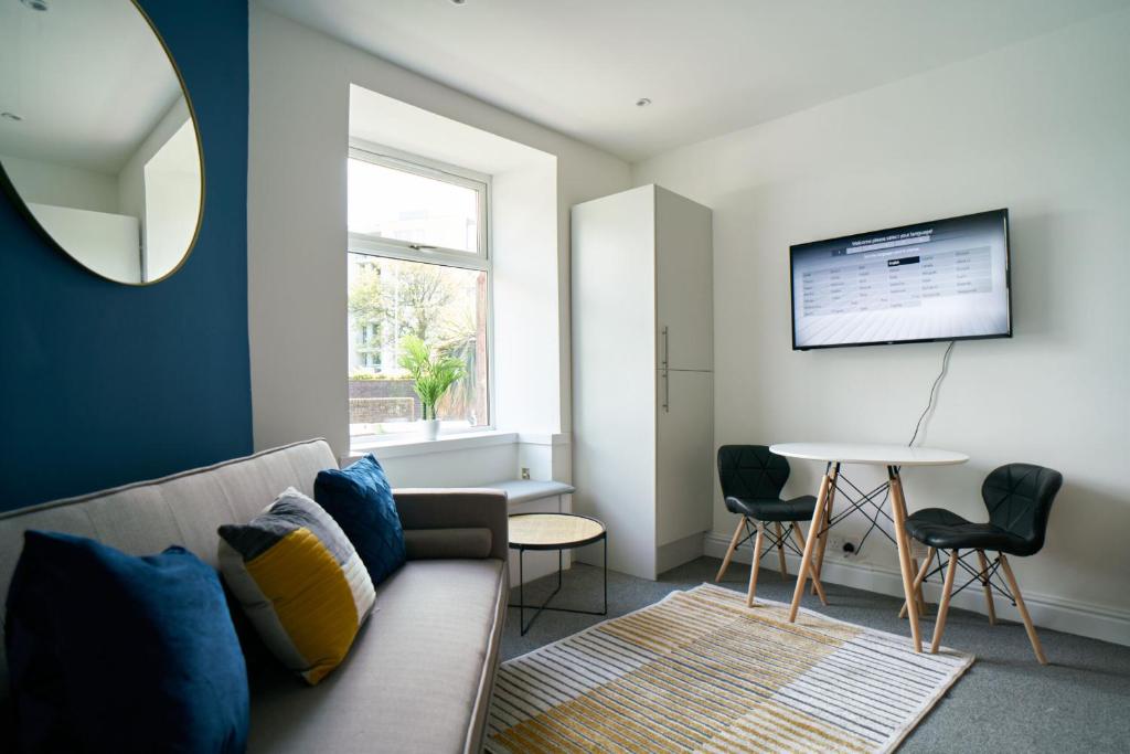 a living room with a couch and a table at Meadow Apartment in Dumbarton