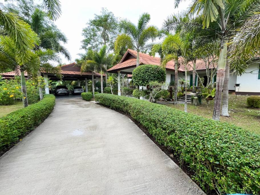 a walkway in front of a house with palm trees at Daras house in Ban Klam