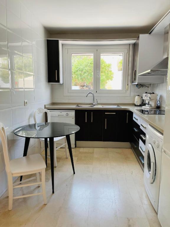 a kitchen with a table and a sink and a stove at Apartamentos Dulcemar Frente al Mar con zona SPA in San José