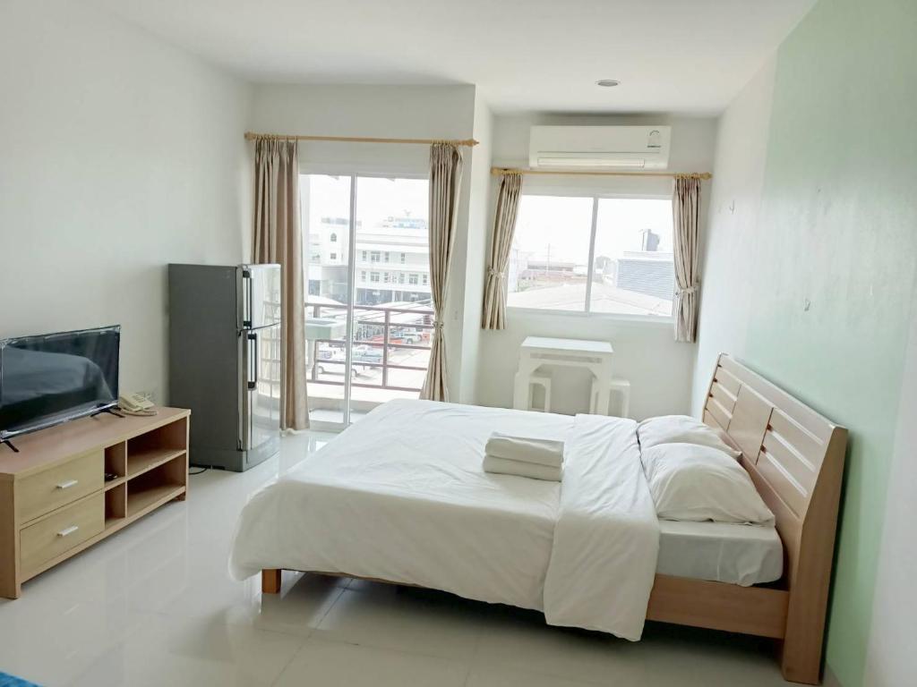 1 dormitorio con cama, TV y balcón en Sawairiang Place, en Nakhon Ratchasima