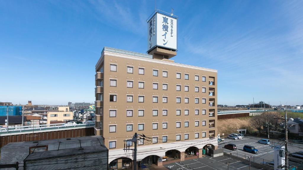 a building with a clock tower on top of it at Toyoko Inn Saitama Misato Ekimae in Misato