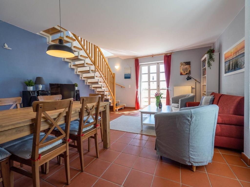 ein Wohnzimmer und ein Esszimmer mit einem Tisch und Stühlen in der Unterkunft Feriendorf Rugana - Komfort Appartement mit 2 Schlafzimmern und Terrasse C48 in Dranske