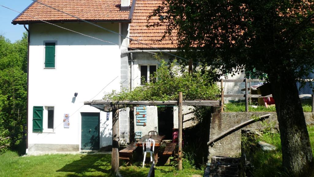 mały biały dom z bramą przed nim w obiekcie Cascina Marasca Appartamento Viola w mieście Martina Olba
