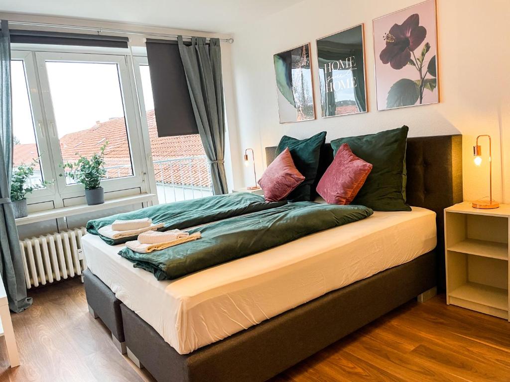 sypialnia z łóżkiem z zielonymi i czerwonymi poduszkami w obiekcie Apartment für 3 Gäste kostenlose Parkplätze und Lift w Hanowerze