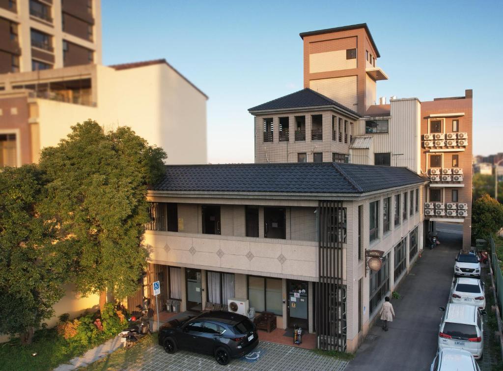 um edifício com um carro preto estacionado em frente dele em Lütel Hotel Xpark Gloria Outlets Shin Kong Cinemas em Dayuan