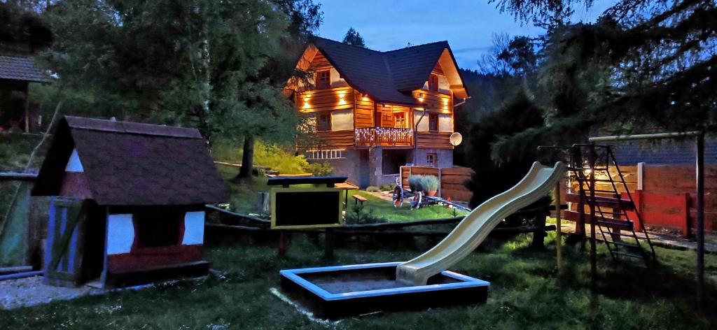 a house with a playground in front of a house at Chata Smrek a kontaktná MINI ZOO in Jezersko