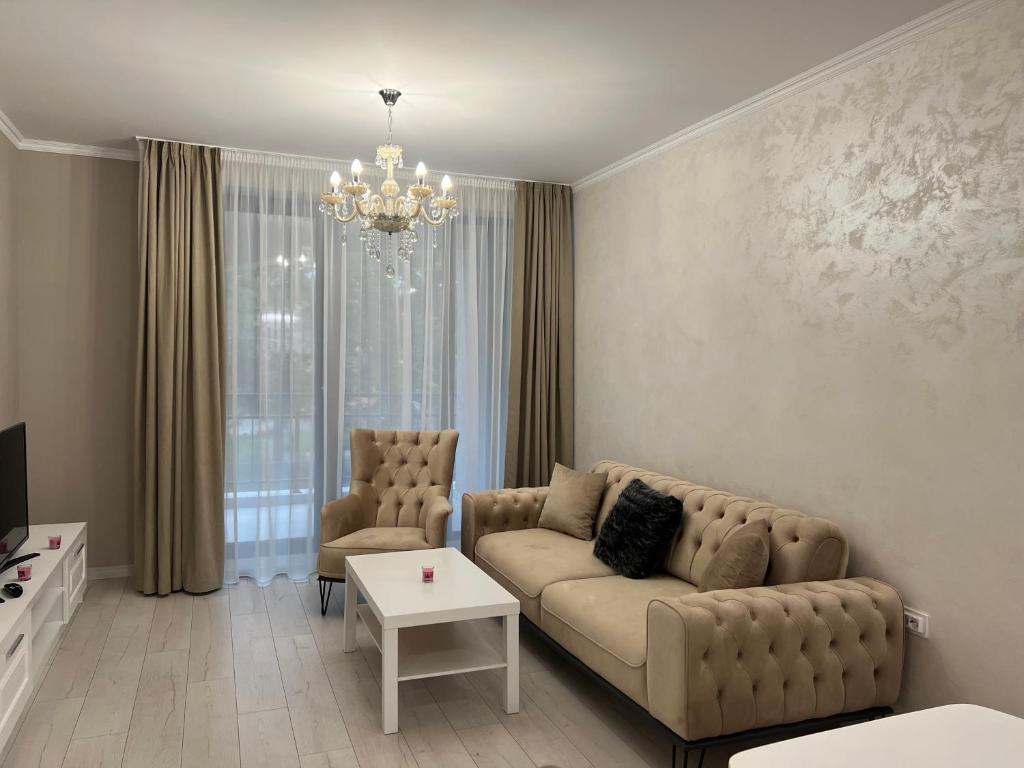 uma sala de estar com um sofá e um lustre em DELUXE APARTAMENTS DARIS em Kazanlŭk