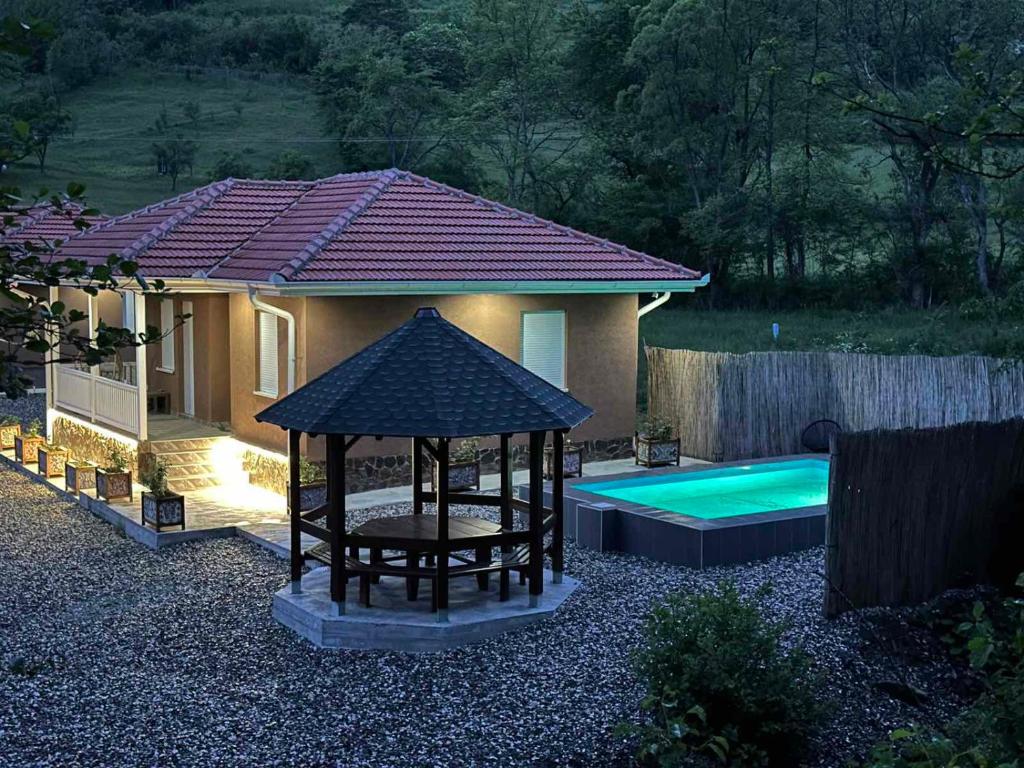 a house with a gazebo and a swimming pool at OAZA in Mokra Gora