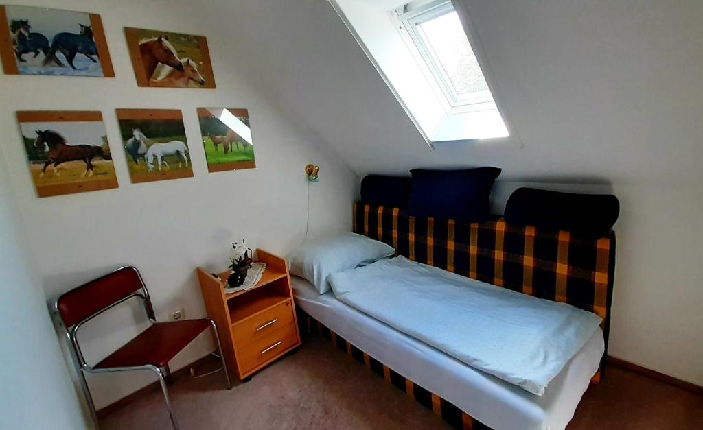 1 dormitorio pequeño con 1 cama y 1 silla en Szalakóta Ház, en Balatongyörök