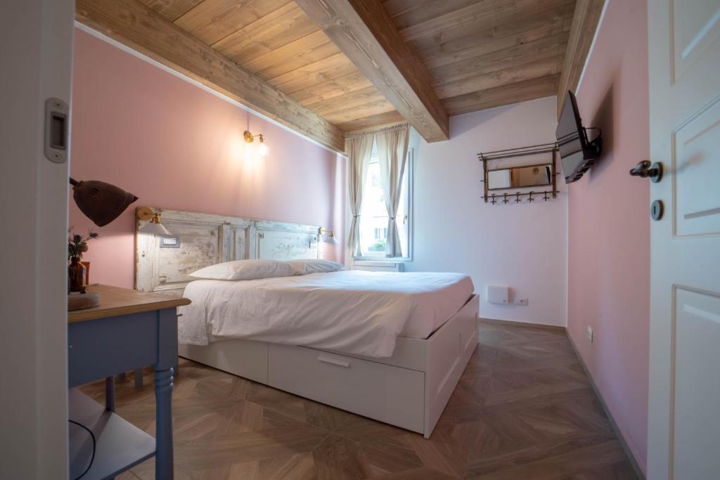 una camera con un grande letto bianco e una scrivania di Le Camere di Olivia a Ravenna