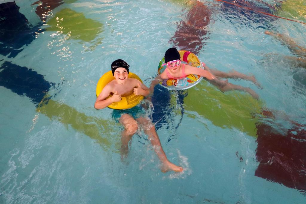 dos personas en una piscina con frisbees en Osprey Hotel, en Naas