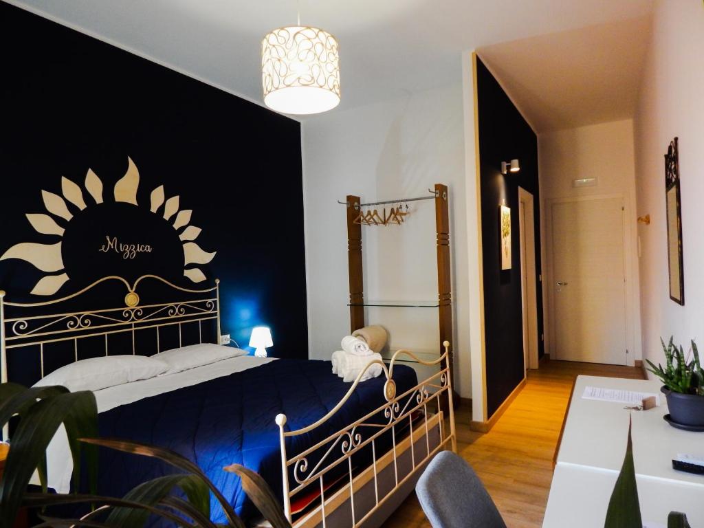 a bedroom with a large bed with a blue blanket at Camurria in Piazza Armerina