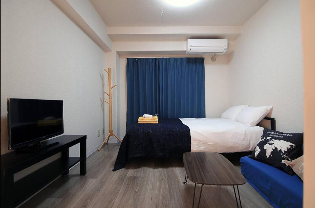 a hotel room with a bed and a tv at SG LION HOUSE 2P Free pocket Wi-fi! in Tokyo