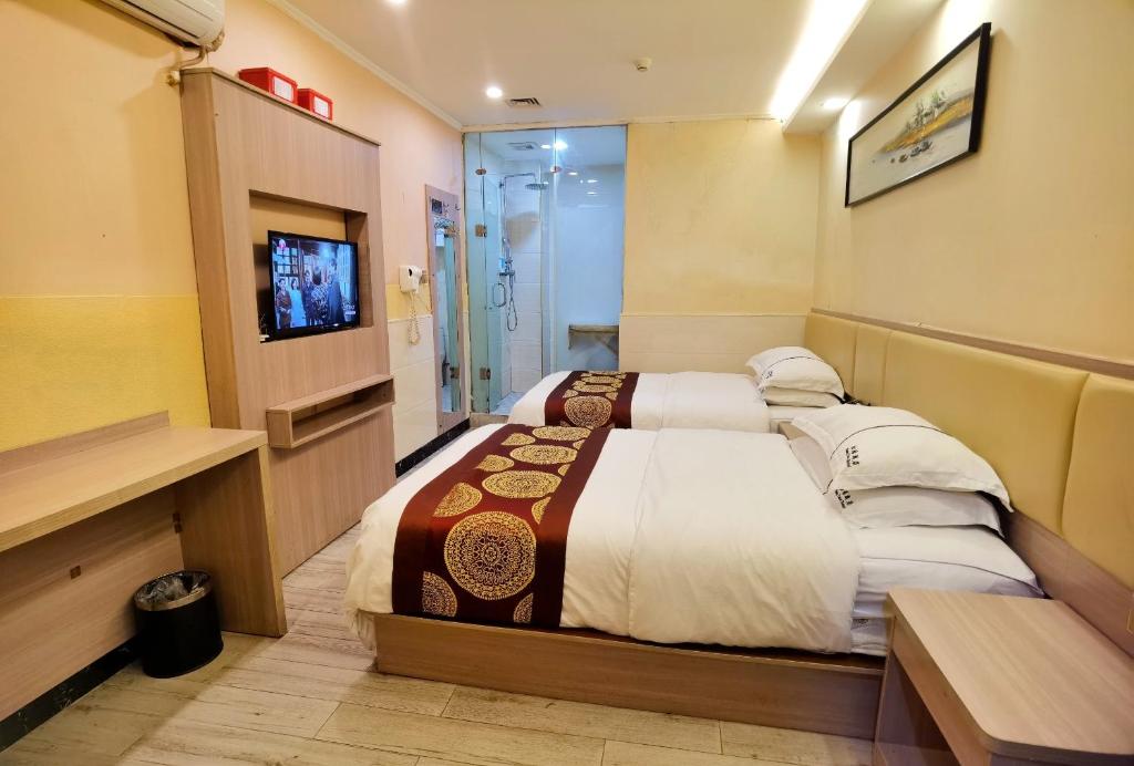 a hotel room with a bed and a television at Songyuan Hotel 松缘酒店 in Shenzhen