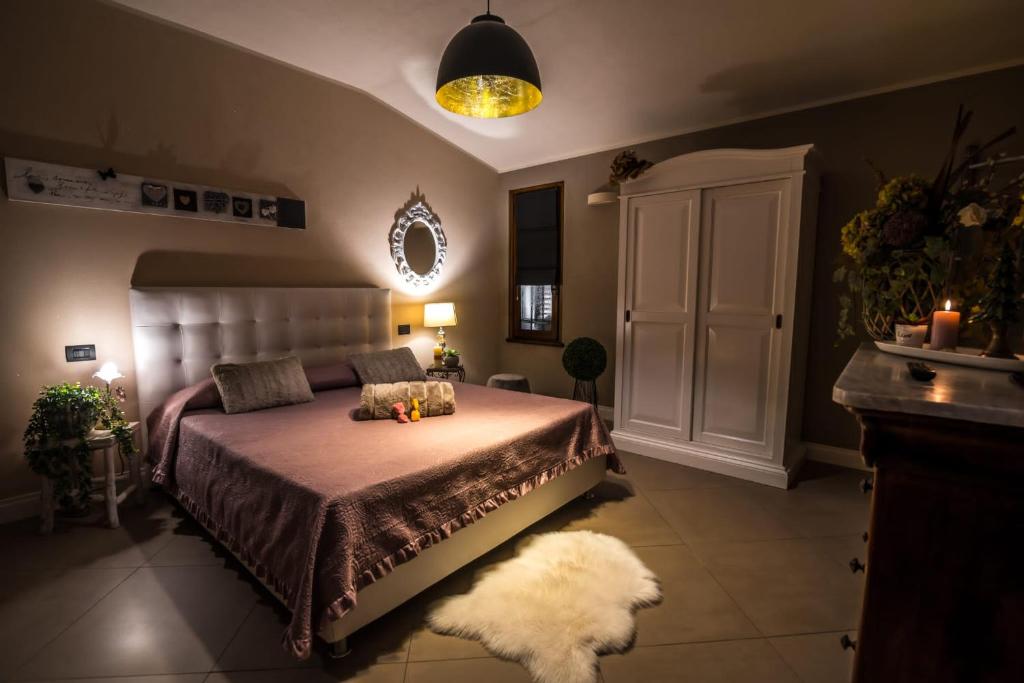 a bedroom with a large bed and a white rug at L'antica Fornace di Barale Emanuela in Vicoforte