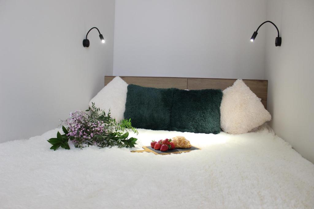a bed with flowers and a plate of food on it at Апартаменты Comfort Life 93 in Almaty