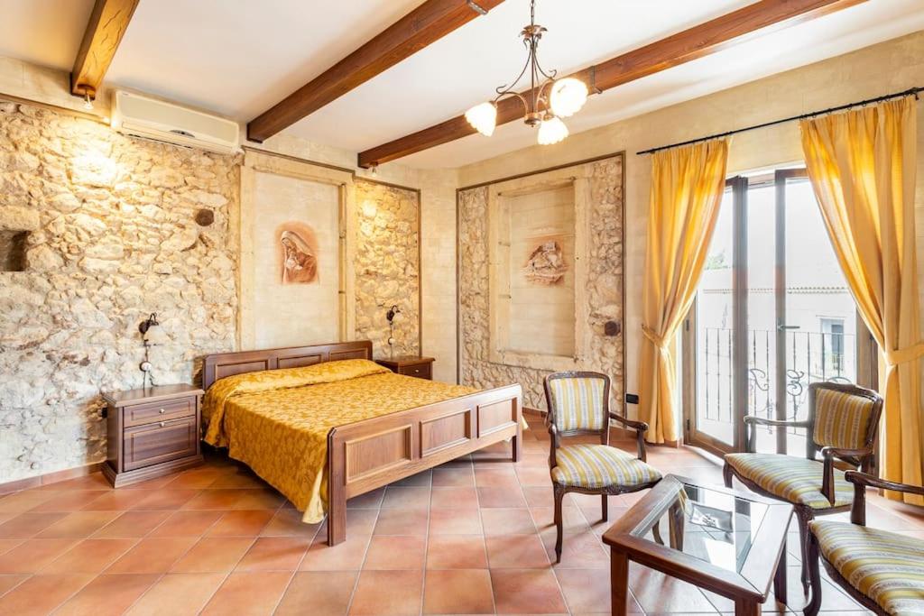 a bedroom with a bed and a couch and chairs at Luxury Accommodation in Santa Domenica