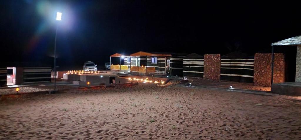 una spiaggia notturna con un lampione di Wadi Rum Quiet Sky a Wadi Rum