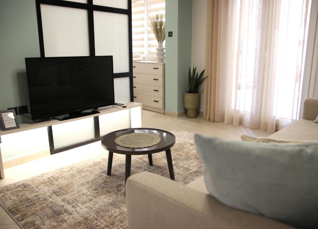 een woonkamer met een tv en een bank en een tafel bij CasaTu 2 Apartments in Komotini