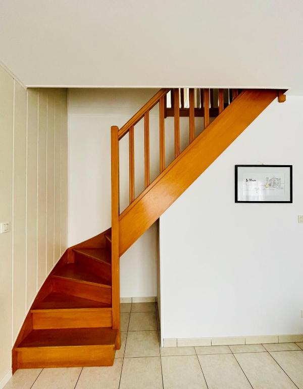 a wooden staircase in a room with white walls at Maison entière Domido in Changé
