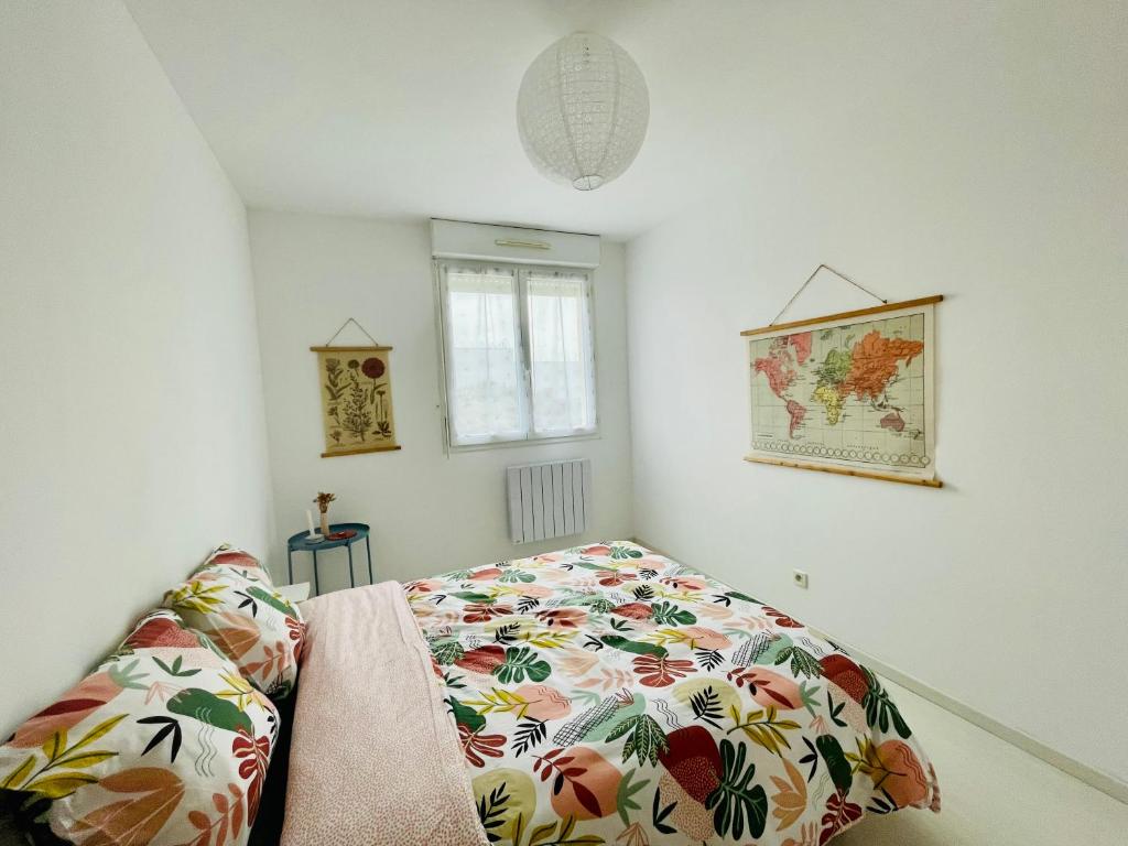 a bedroom with a bed with a flowered blanket at Maison entière Domido in Changé