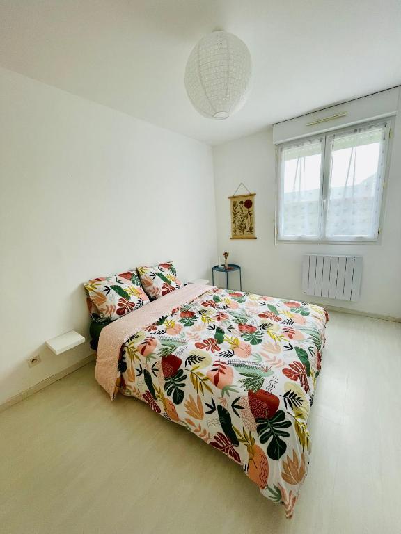 a bedroom with a large bed with a colorful bedspread at Maison entière Domido in Changé