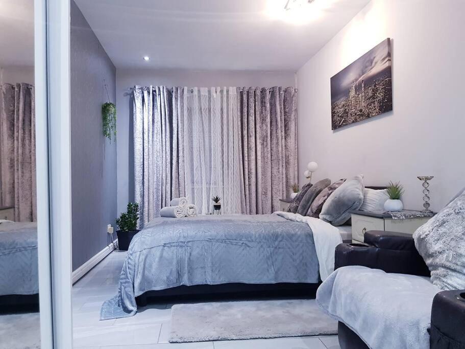 a white bedroom with a bed and a window at Burburry Studio Apartments in Cleethorpes